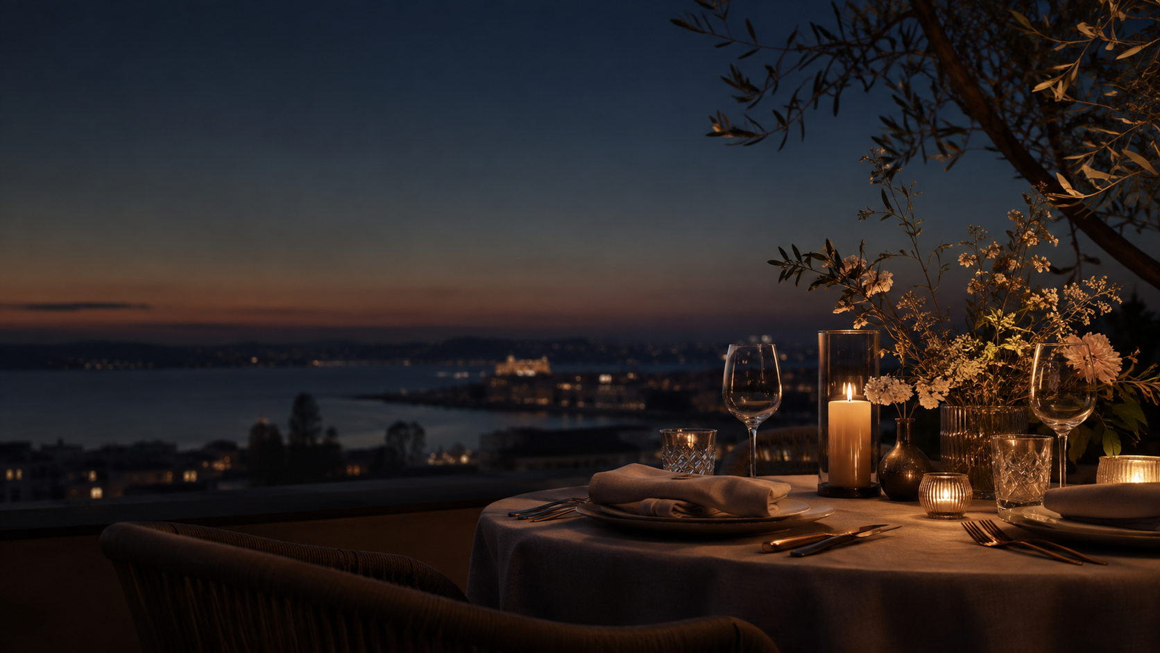 Candlelit table set for an intimate evening overlooking the sea at dusk
